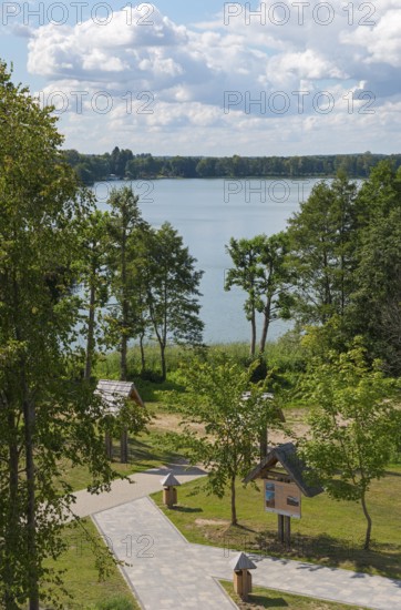 Lake with surrounding trees and well-kept path under a blue sky with clouds, view from the observation tower to the lake Ilinsk, graduation tower, spa town Milomlyn, Milomlyn, Lviv, Warmia-Masuria, Poland
