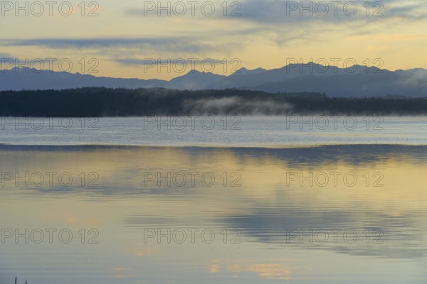 Calm waters with a mountain backdrop under a pastel-coloured sky, Lake Mahinapua, Ruatapu, South Island, New Zealand