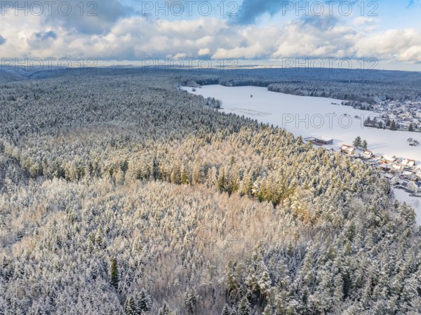 Snowy forest and fields taken from the air, blue sky with clouds, cold and wide scenery, Oberreichenbach, Black Forest, district Calw, Germany