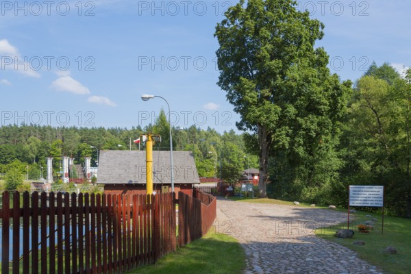 Paved path with trees and view of the lock, sunny summer day, Sluza Kurzyniec, Sluza, lock, border between left Belarus and right Poland, Kanal Augustowski, Augustow Canal, Rudawka, Plaska, Plaska, Powiat Augustowski, Podlaskie, Podlaskie, Poland