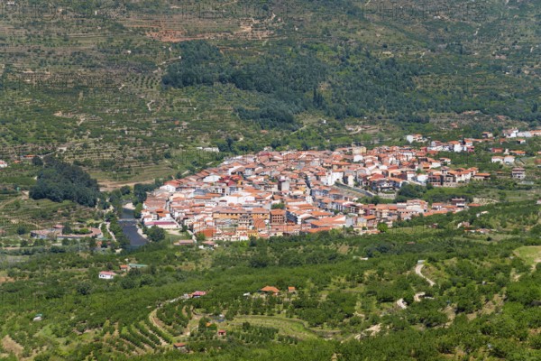 A village with white and red houses nestled in a green, hilly landscape, Cabezuela del Valle, Valle del Jerte, Jerte Valley, Cáceres, Caceres, Extremadura, Spain