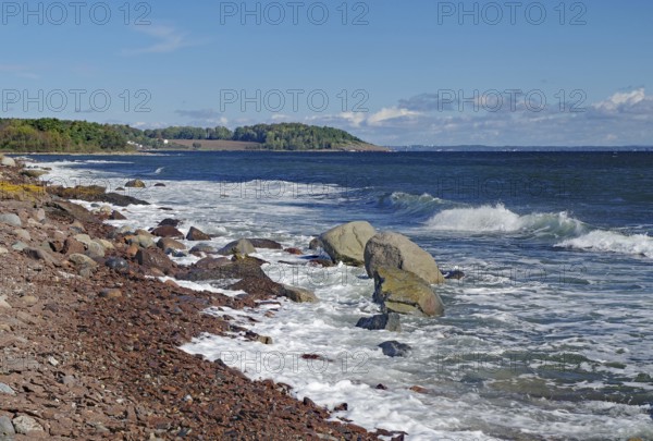 Rocky coast with gentle waves, clear skies and a green coastline, Tönsberg, Oslofjord, Norway