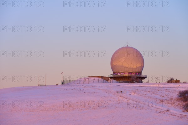 A radar station radome on a snow-covered hill at sunset with pink sky, winter, Wasserkuppe, Gersfeld, Rhön, Hesse, Germany