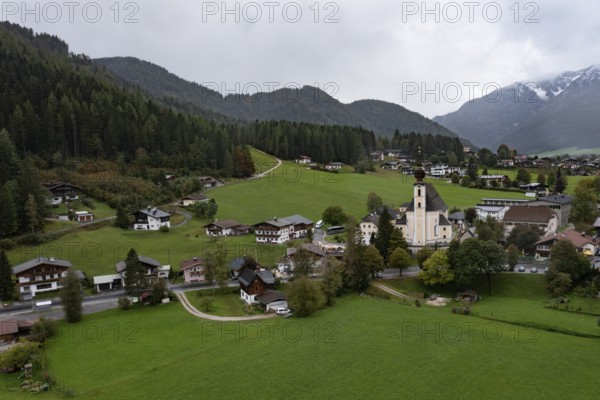 Drone shot, view of village with parish church, Waidring, Pillerseetal, Tyrol, Austria