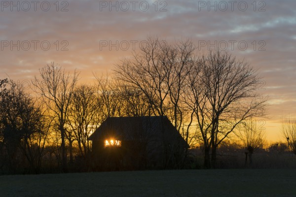 Sunset, sky burning, evening sun shining through a window of a house, house on the Dijkweg, Holwierde, Eemsdelta, Groningen, Netherlands