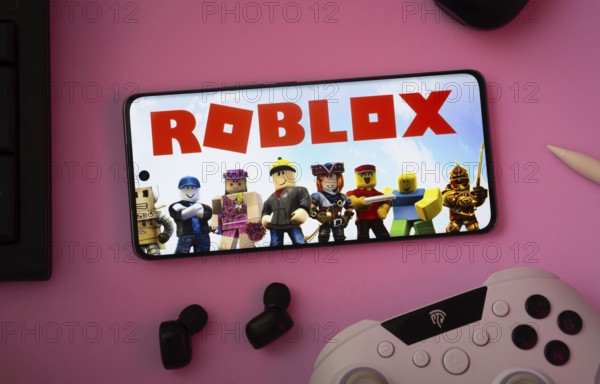 Dhaka, Bangladesh- 26 July 2025: A close-up of a gamepad with the Roblox seen on smartphone