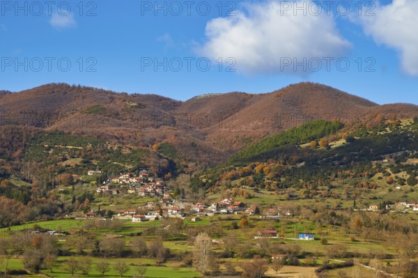 View of a village surrounded by autumnal hills and meadows, Erymanthos Mountains, northwest of the Peloponnese peninsula, Peloponnese, Greece