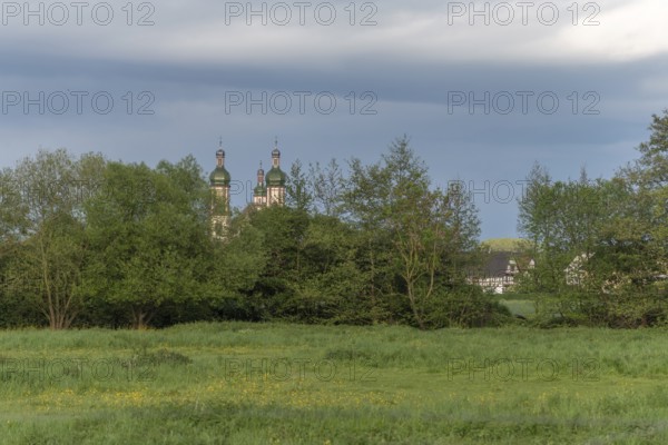 The baroque Saint-Maurice church in Ebersmunster surrounded by meadows in spring. Bas Rhin, Alsace, France