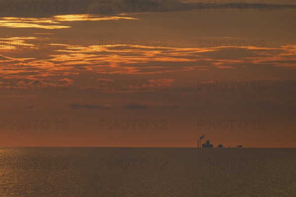 Factory on the horizon, sea surface, evening mood, Baltic Sea