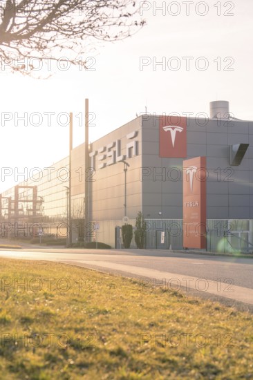 Tesla production facility in the sunset with grey building and modern logo, Tesla, Holzgerlingen, Germany