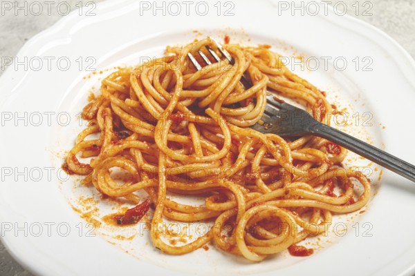 A plate with leftover spaghetti bolognese, no people