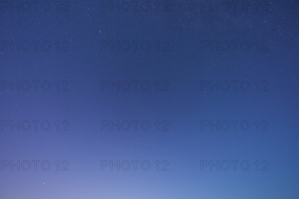 A clear starry sky with soft blue tones at dusk creates a peaceful atmosphere, Spessart, Bavaria Germany