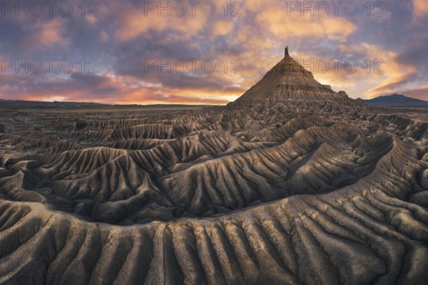 Stunning landscape of Factory Butte in Utah bathed in the warm glow of sunset with dramatic sky and textured terrain