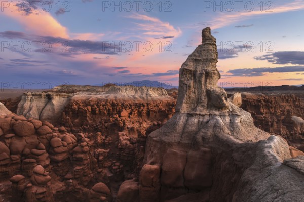 Majestic sandstone formations in Goblin Valley State Park, Utah, glow under a vibrant sunset sky, highlighting the park's unique geology and natural beauty