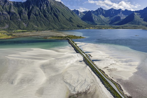 Aerial view of a bridge over turquoise sea at a sandy beach, fjord Grunnforfjorden, Lofoten islands, Norway