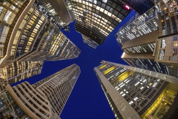 The glowing skyscrapers of Frankfurt's banking skyline rise into the blue evening sky, Frankfurt am Main, Hesse, Germany