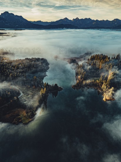 Autumn sunrise in the foothills of the Alps with fog at Illasbergsee and Forggensee near Halblech in Allgäu, Bavaria, Germany