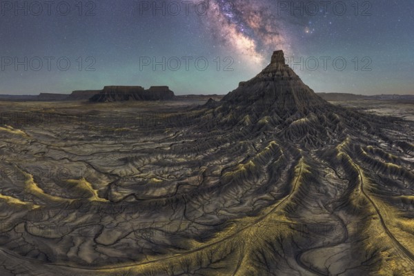 A breathtaking view of the Milky Way galaxy illuminating a majestic sandstone desert landscape in Utah, United States, showcasing nature serene beauty and cosmic wonder