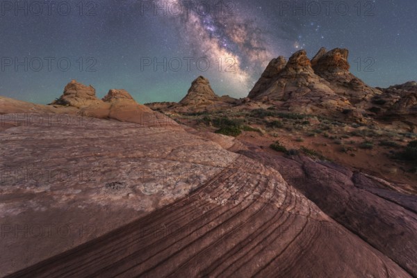 Stunning view of the Milky Way illuminating a rocky desert with unique formations, capturing the awe inspiring beauty of nature and the cosmos at night in Coyote Buttes, Arizona
