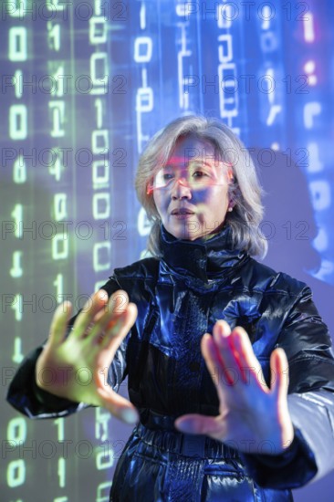 An elderly Asian woman engages with the metaverse using virtual reality technology. She wears futuristic glasses, immersed in a digital environment with binary code projections