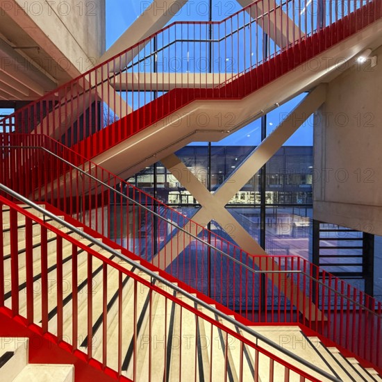 Staircase with signal red color scheme in seminar building H of Bochum University in the evening with a view of BlueBox Bochum, North Rhine-Westphalia, Germany