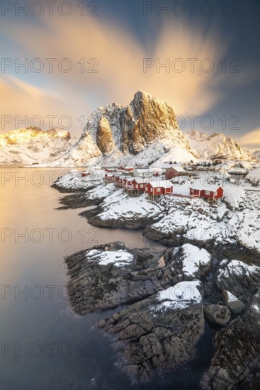 Rorbuer fishing huts in front of snow-covered mountains in winter, Hamnøy, Moskenesøy, Lofoten, Norway