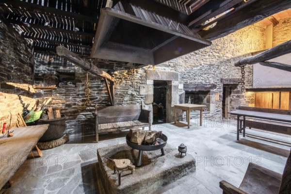 Traditional Lugo, Spain country house featuring rustic stone walls and a large open hearth in a historically preserved interior setting