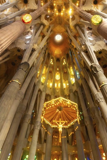 Sunlight illuminating the canopy and crucifix hanging from the ceiling of the sagrada familia in barcelona, spain