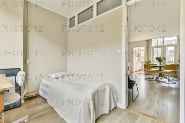 A serene living space showcasing a minimalist design with soft lighting, wooden floors, and a simple bed, perfect for relaxation and tranquility