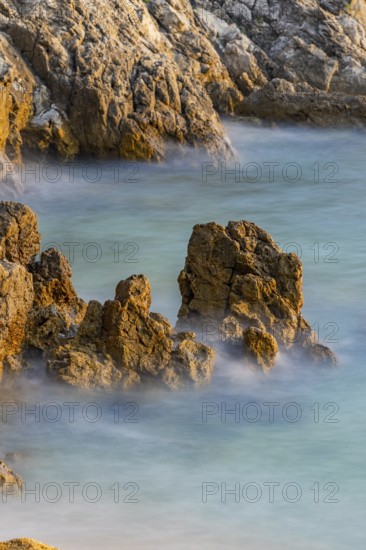 Crystal clear and turquoise water on the beach of Ustrine Bay on a sunny day at sunset on the island of Cres, long exposure, Croatia