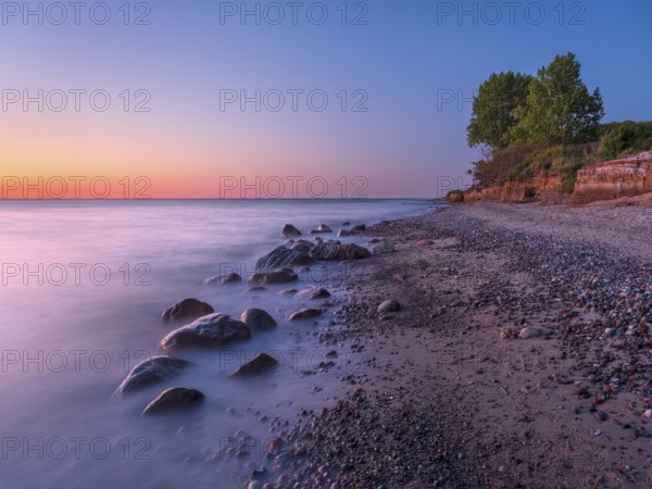 Unspoiled secluded stretch of coast with cliffs and boulders in the evening light on the Baltic Sea beach, near Rerik, Mecklenburg-Western Pomerania, Germany