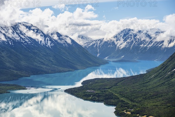 View of snowy mountains in spring and turquoise Kenai Lake with reflection, Slaughter Ridge Trail, Cooper Landing, Kenai Peninsula, Alaska, USA