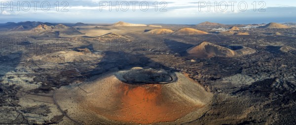 Caldera Colorada volcano, picturesque volcanic landscape with volcanic craters and lava fields in morning light, Parque Natural de Los Volcanes, aerial view, Lanzarote, Canary Islands, Spain