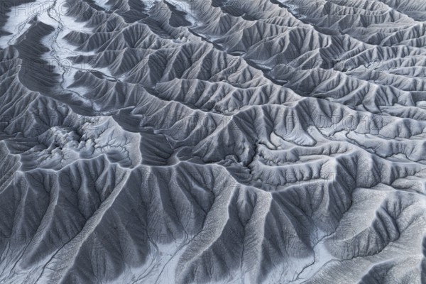 Captivating aerial shot capturing the intricate and rugged landscape of Caineville Mesa, near Hanksville, Utah, showcasing a tapestry of eroded rock formations and drainage patterns