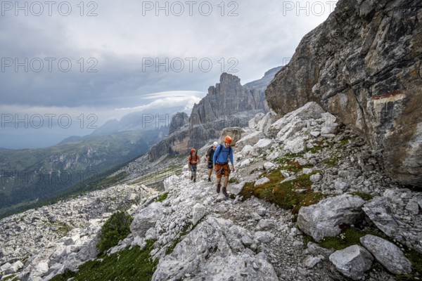 Three mountaineers on a hiking trail, rocky mountain landscape, Via Ferrata SOSAT via ferrata, Brenta Mountains, Trentino, Italy