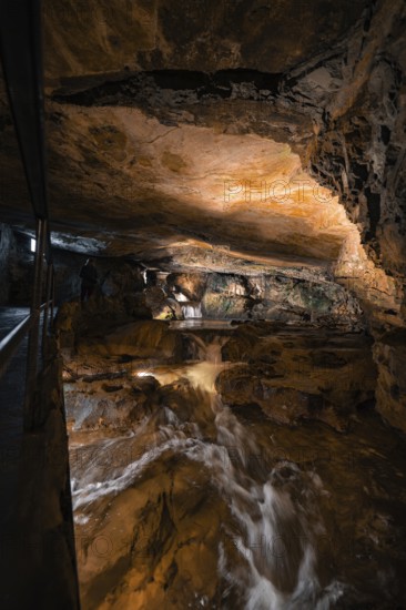 Rushing watercourse in a hilly cave environment, illuminated, adventurous, Beatus Caves, Switzerland