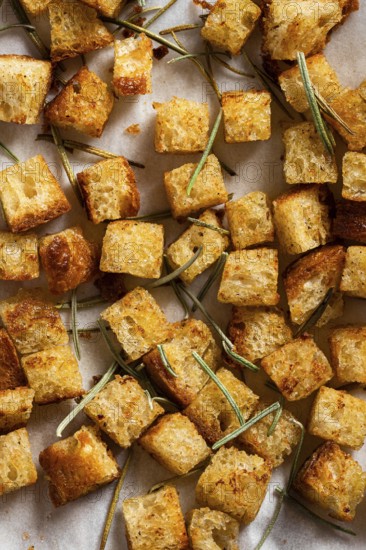 A close-up of golden croutons and rosemary, styled on a white background with tiles, capturing the essence of homemade cauliflower curry soup Elegant and healthy presentation