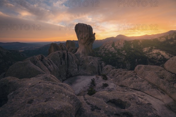 Captivating sunset view over the dramatic rock formations in Pedriza, Madrid. The warm hues paint the sky, highlighting the rugged beauty of the Sierra de Guadarrama landscape