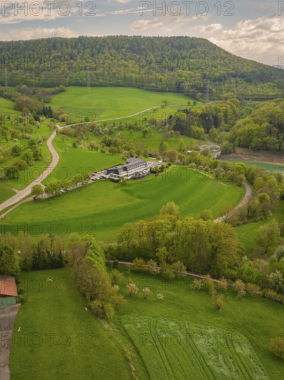 Hotel in the middle of a green hilly landscape with surrounding fields, Glems reservoir, Swabian Alb, Germany