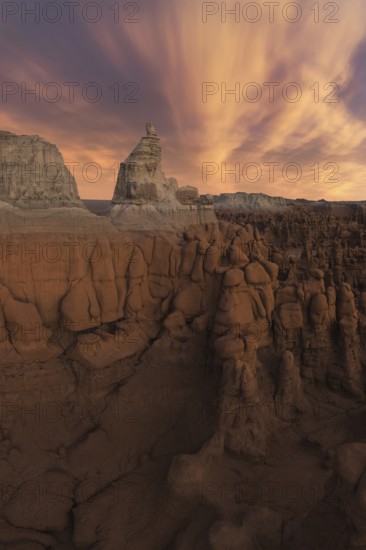 A stunning view of unique sandstone formations under a dramatic sky in Goblin Valley State Park, Utah. The landscape showcases natural erosion's artistry