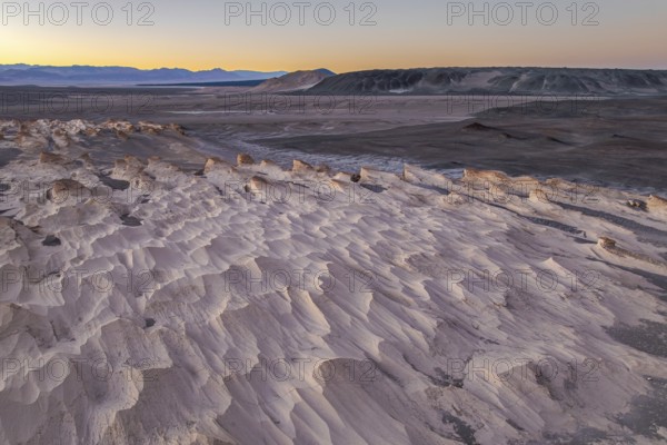 Stunning view of the pumice field in Catamarca, Argentina, highlighted by the soft light of sunrise. The landscape features unique rock formations and vast plains