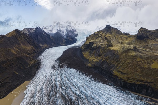 Stunning aerial capture of Vatnajökull Glacier winding through the rugged mountains of Vatnajökull National Park in Iceland, showcasing the icy expanse and raw, natural beauty