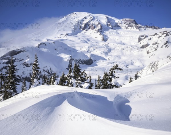 Pristine snow shapes created by strong winds in front of Mount Rainier, Washington during winter provide a breathtaking view