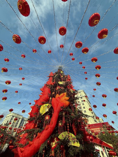 Vibrant Chinese New Year decorations adorn the streets with red lanterns and festive elements, creating a stunning and joyful atmosphere under a bright blue sky