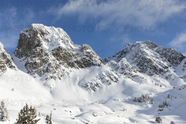 A breathtaking view of snow-laden mountains under a clear blue sky, perfect for adventurous winter sports