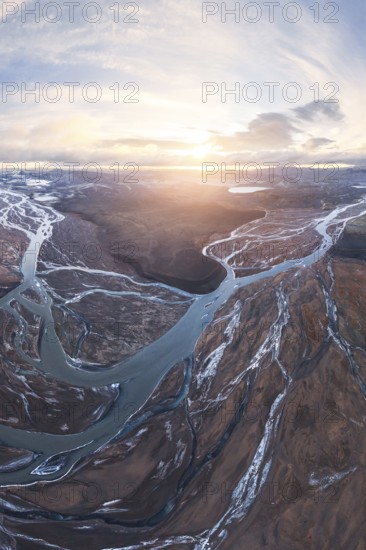 Breathtaking aerial view of meandering rivers in Iceland's Highlands, capturing the dramatic landscape at sunrise. Stunning natural patterns and earthy tones are highlighted