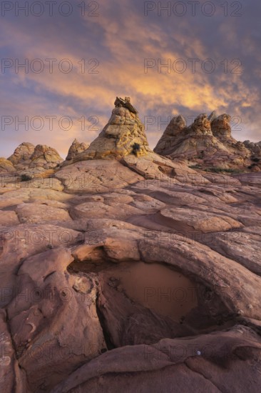 Dramatic sunset illuminates the unique rock formations at Coyote Buttes in the Paria Canyon-Vermilion Cliffs Wilderness, Arizona, enhancing the vivid landscapes