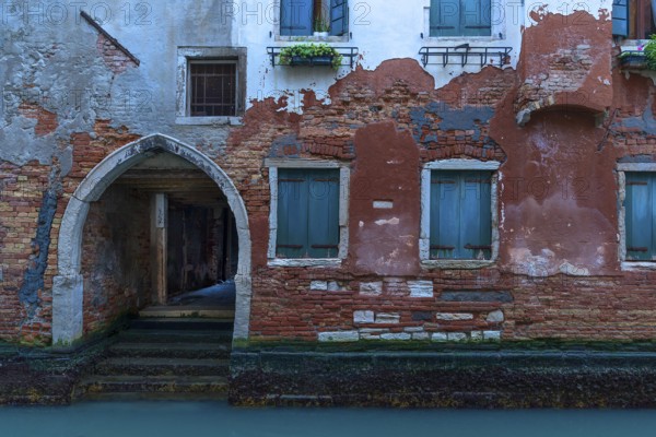 Old house with gate entrance to the canal, Venice, Veneto, Italy