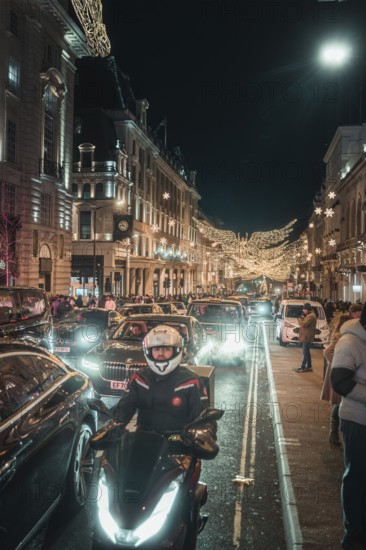 Nocturnal street scene with traffic, motorbikes and bright lighting, New Year's Eve London, Great Britain