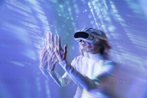 An elderly Asian woman engages with the digital world using a VR headset, illustrating the blend of technology and age diversity in the metaverse. Blue light surrounds her